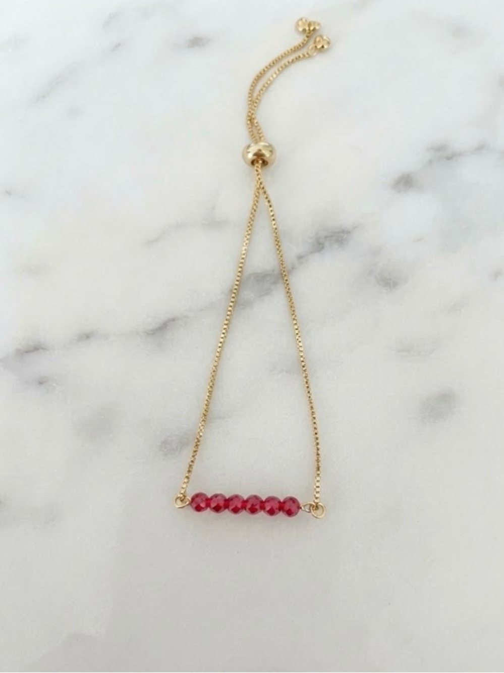 Gold Bracelet with Red Bead Accent